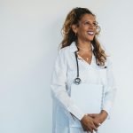 Smiling patient talking to private GP about referral in modern clinic
