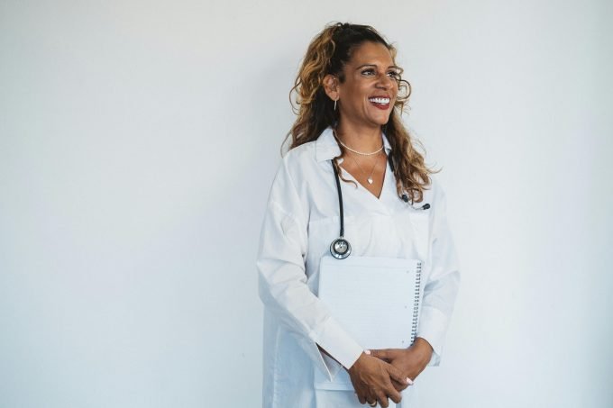 Smiling patient talking to private GP about referral in modern clinic